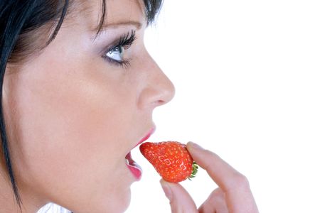Female model eating a strawberry on a white background