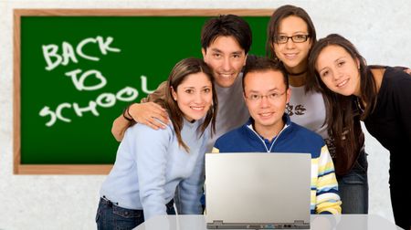 Casual group of students smiling in a classroom with a blackboard in the background with the words back to school