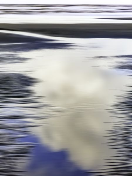 Abstract of large tidal pool reflecting morning clouds on sandy beach along Pacific coast of Olympic Peninsula in Washington, for themes of nature, transience, the environment