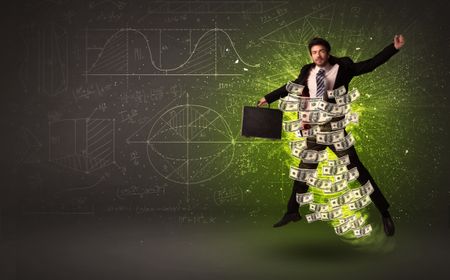 Cheerful businesman jumping with dollar banknotes around him on background