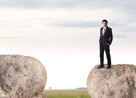 Young businessman standing on edge of rock mountain 