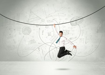 Businessman hanging on a rope with analysis and graphs background