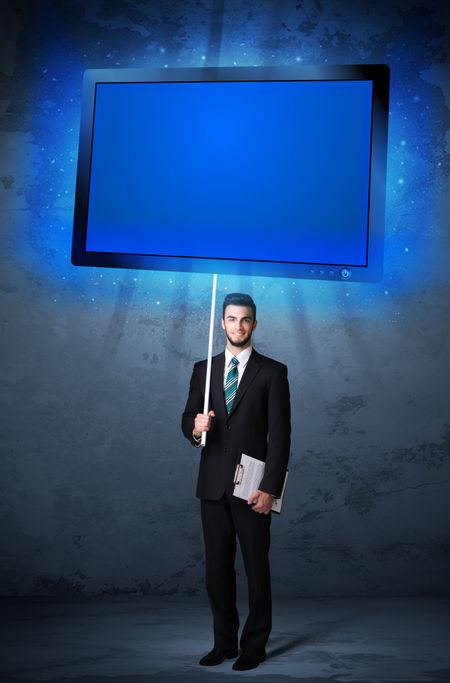 Young businessman holding a big, blue shining tablet 
