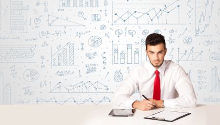 Businessman sitting at white table with hand drawn diagram background