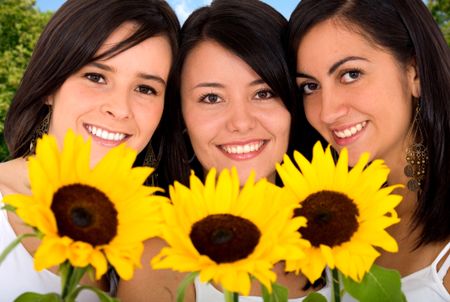 beautiful girls with yellow sun flowers smiling outdoors