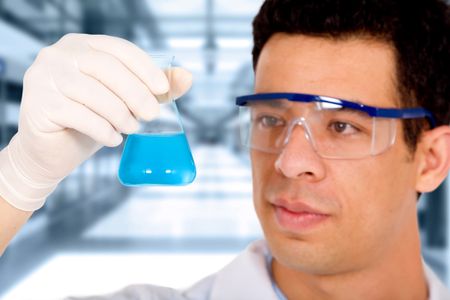 scientist in a science laboratory - holding a blue test tube