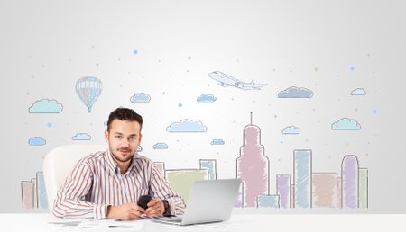 Attractive young businessman with city sky-scape background