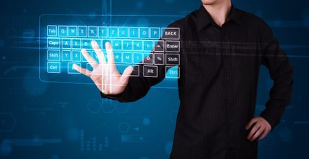 Young businessman pressing virtual type of keyboard