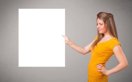 Pretty young woman presenting white paper copy space