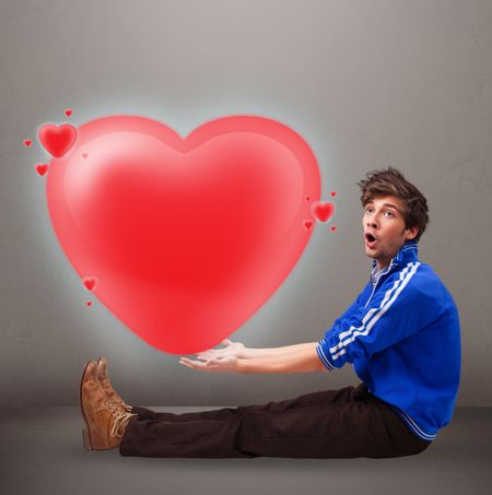 Handsome young man holding lovely 3d red heart
