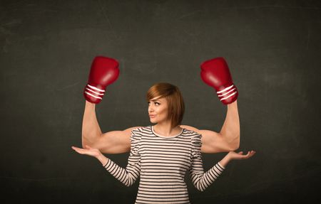 Pretty young woman with strong and muscled boxer arms concept