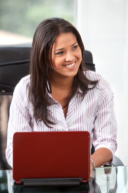 business girl on a laptop in an office smiling
