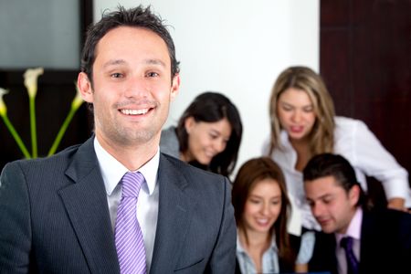 business man smiling leading a team in an office