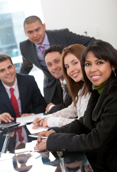 Business people at a staff meeting smiling