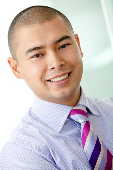 attractive asian business man smiling in an office