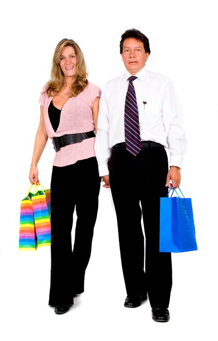 couple with shopping bags walking towards the camera - isolated over a white background