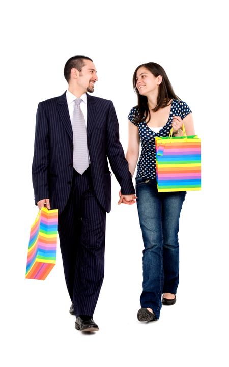 couple walking with shopping bags while talking - isolated over a white background