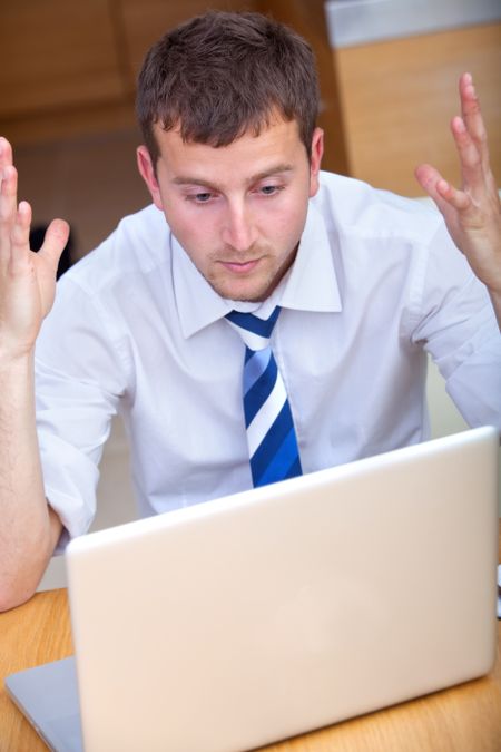 frustrated young business man arguing with  the laptop