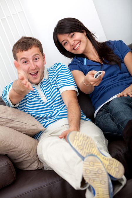 man and woman watching television on a sofa