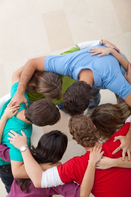 Team of people hugging making a circle - togetherness concepts