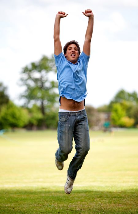 Casual young man jumping outdoors from excitement