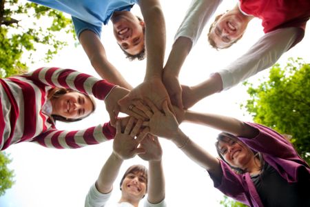 casual-group-friends-outdoors-hands-middle-33721813 Casual group of friends outdoors with hands in the middle