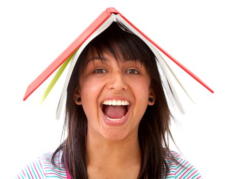 Excited student with a book on top of her head isolated