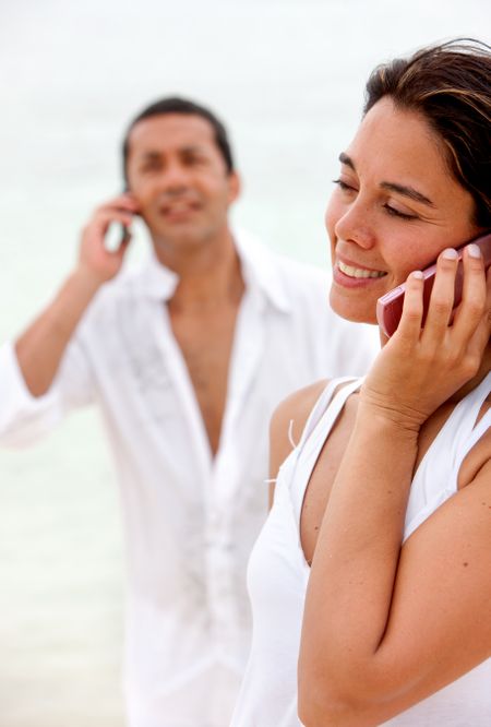 Beautiful beach couple talking on the phone