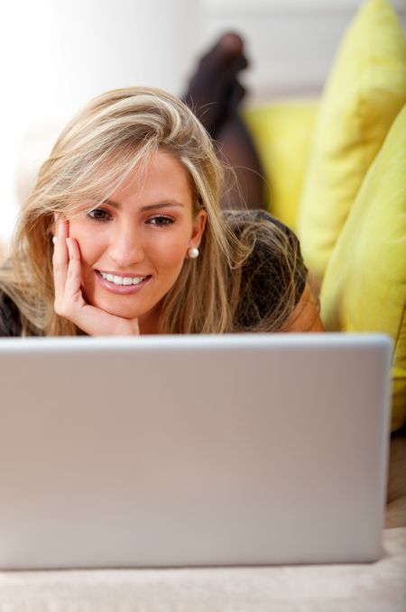 Business woman with a laptop lying on a couch