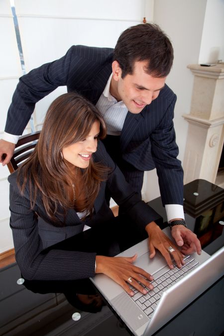 Business couple working on a laptop in an office
