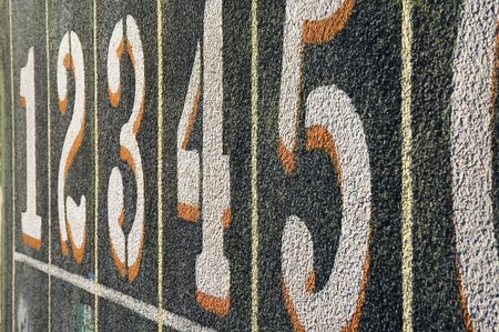 Lane numbers at starting line on weathered outdoor collegiate track
