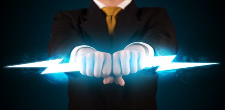 Business man holding glowing lightning bolt in his hands concept