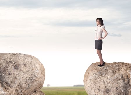 Young businesswoman standing on edge of rock mountain
