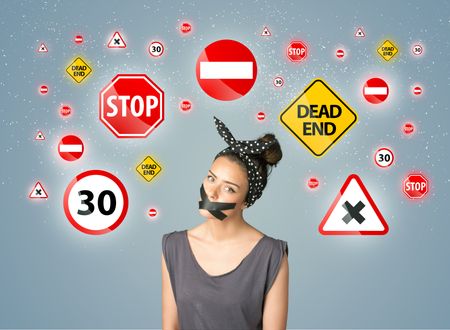 Young woman with taped mouth and traffic signals around her head