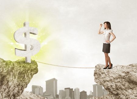 Businesswoman standing on the edge of mountain with a shining dollar mark on the other side 
