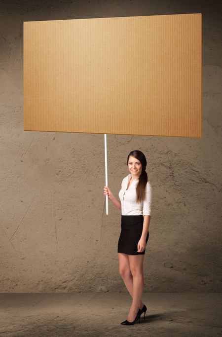 Young businesswoman holding a blank cardboard 