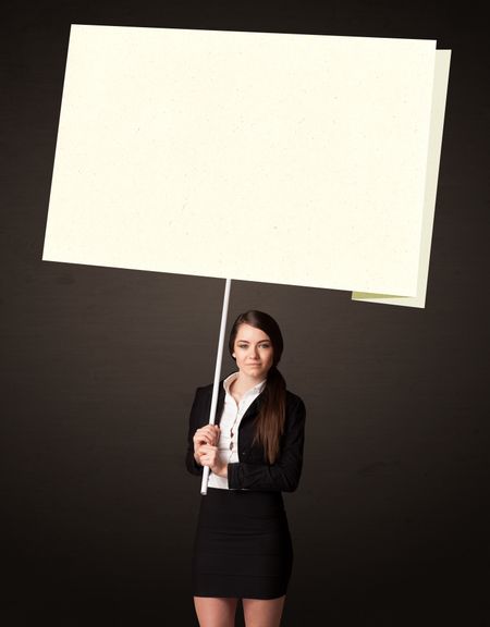Young businesswoman holding a big, white post-it paper 