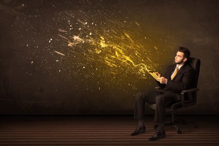 Businessman with tablet and energy explosion on background concept
