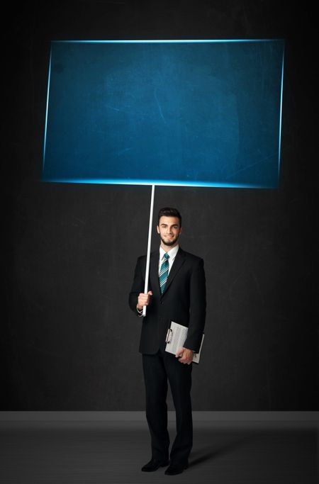 Young businessman holding a big, blue board