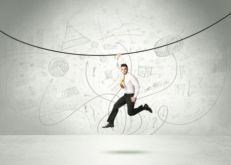 Businessman hanging on a rope with analysis and graphs background 