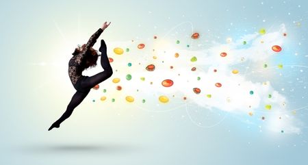 Beautiful woman jumping with colorful gems and crystals on the background concept