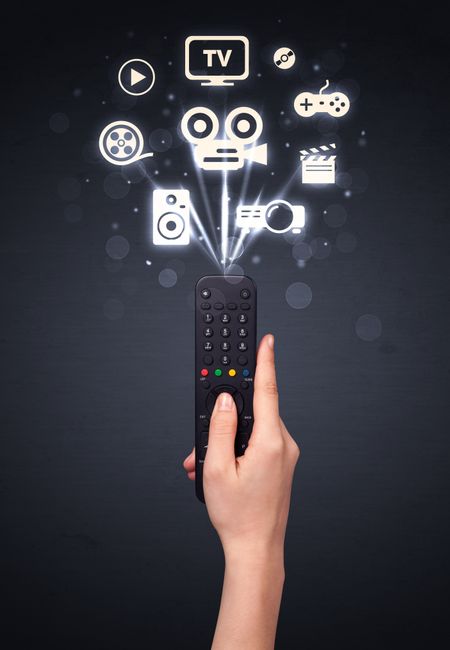 Hand holding a remote control, media icons coming out of it 