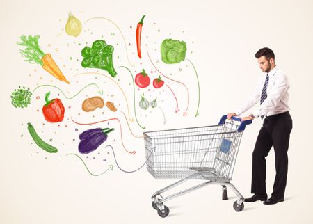 Businessman pushing a shopping cart and healthy vegetables coming out of it 