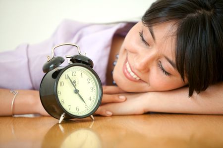 business young woman watching an alarm clock