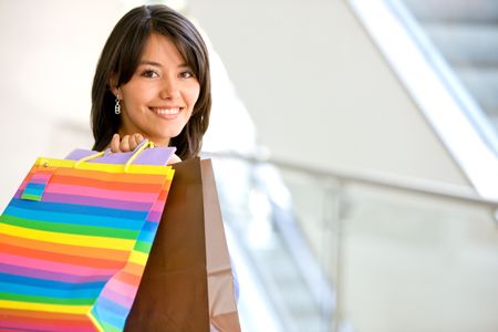 beautiful girl smiling with shopping bags in a mall