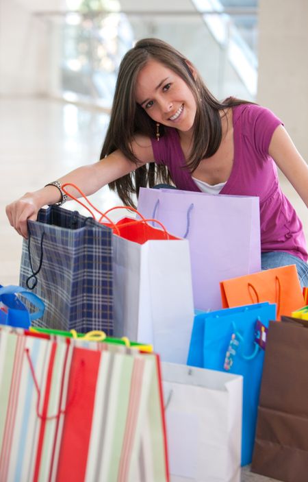 beautiful girl smiling with shopping bags in a mall