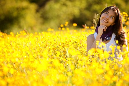 thoughtful woman smiling on a beautiful meadow