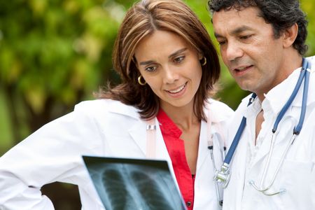 couple of doctors looking at an x-ray outdoors