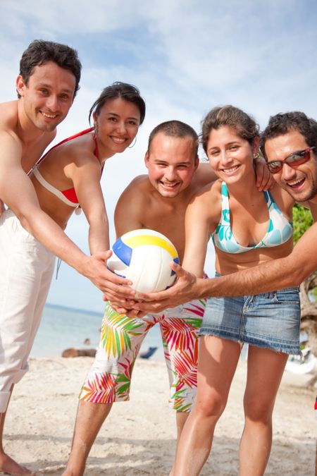 Group of friends standing at the beach with a ball