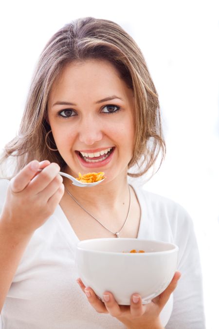 casual woman having breakfast and smiling - isolated over a white background